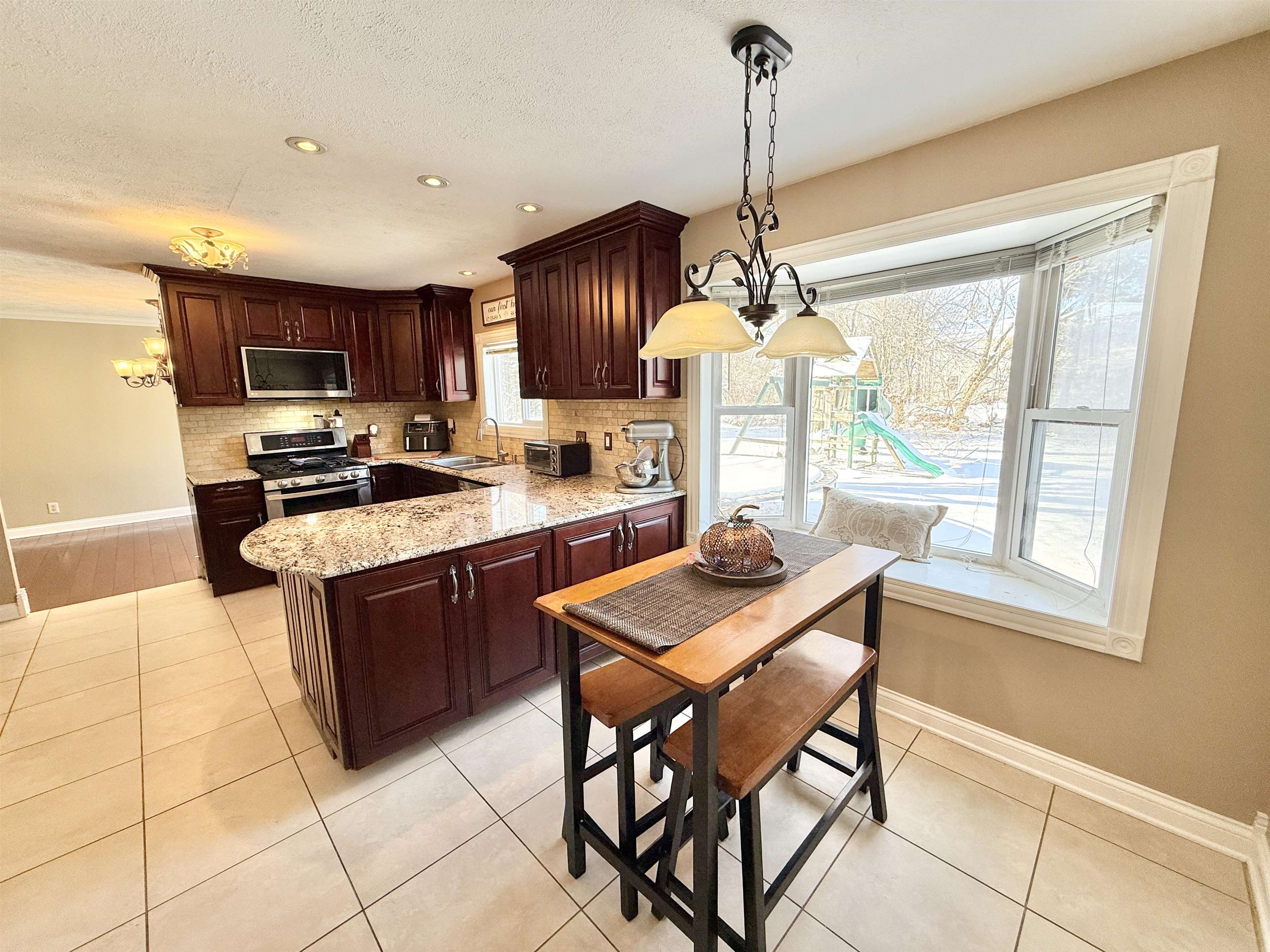 120 Lamplighter Loop Southeast Poplar Grove, IL 61065 - Photo 13 of 30 a kitchen with stainless steel appliances granite countertop a stove a sink a oven a dining table and chairs