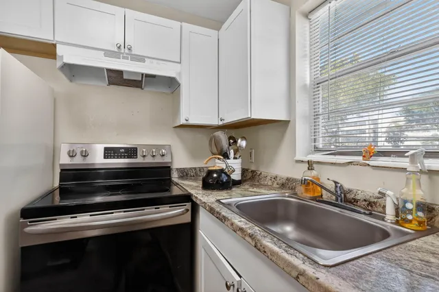a kitchen with stainless steel appliances granite countertop a sink stove and cabinets