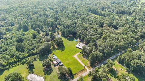 an aerial view of a residential houses with yard and swimming pool