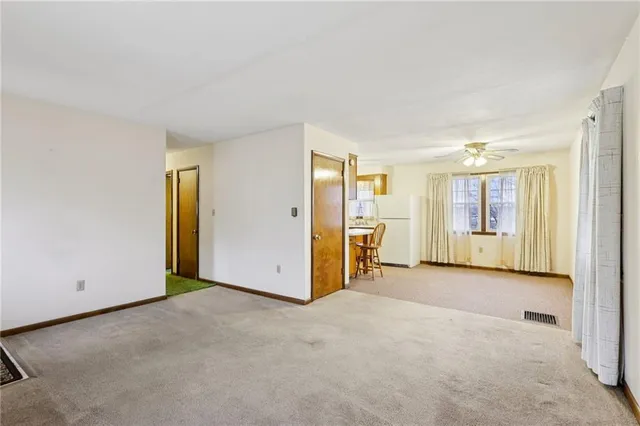 an empty room with a cabinet and mirrors