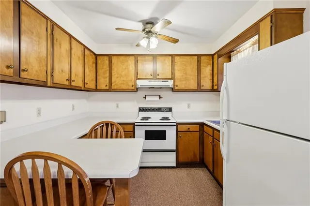 a kitchen with stainless steel appliances granite countertop a sink a stove and refrigerator