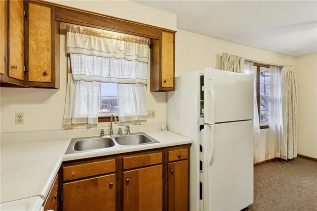a white kitchen with a refrigerator a sink and a cabinets