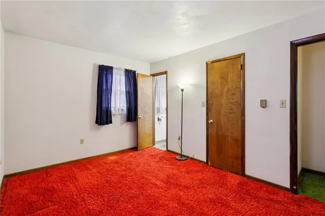 a bedroom with a large bed and a flat tv screen