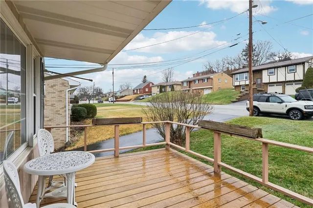 a view of a house and a swimming pool with a couches chairs and wooden floor