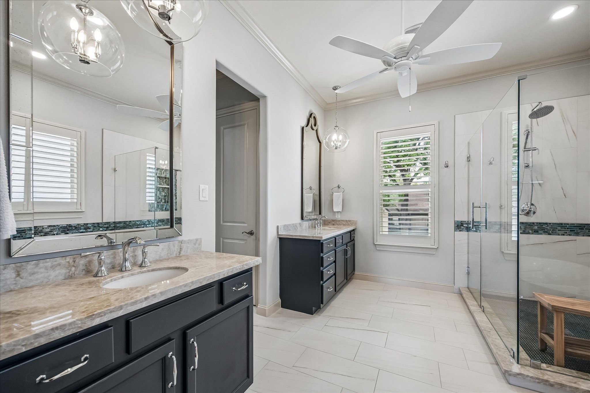 907 Queen Annes Road Houston, TX 77024 - Photo 13 of 31
Renovated primary bath featuring dual vanities with Taj Mahal quartzite countertops, designer lighting, and a spacious walk-in shower.