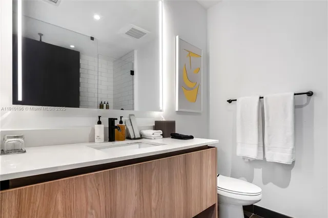 a bathroom with a sink a toilet and a mirror