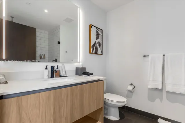 a bathroom with a toilet sink and mirror