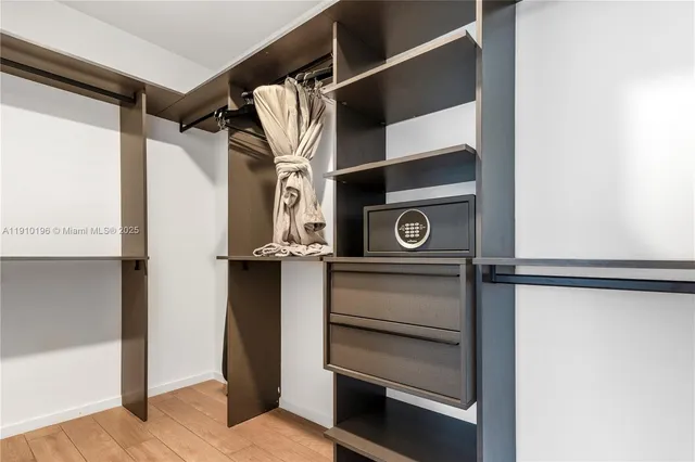a view of walk in closet with clothes and shoes