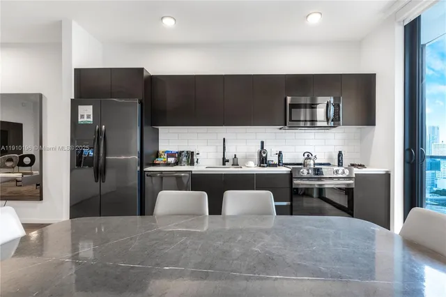 a kitchen with stainless steel appliances granite countertop a refrigerator and a stove