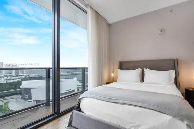 a bedroom with a large window and a balcony