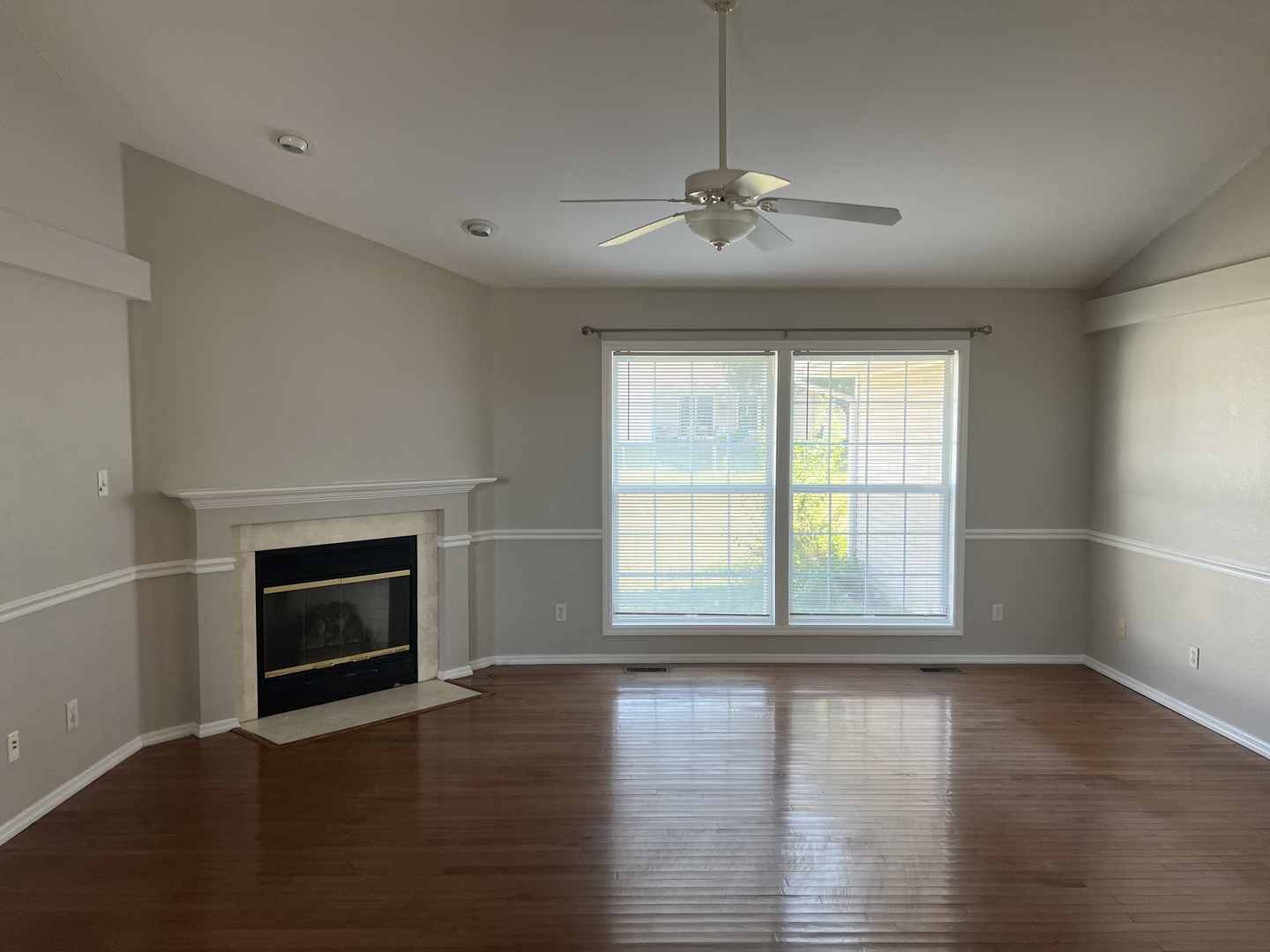 3123 Brookstone Danville, IL 61832 - Photo 2 of 20 an empty room with wooden floor fireplace and windows