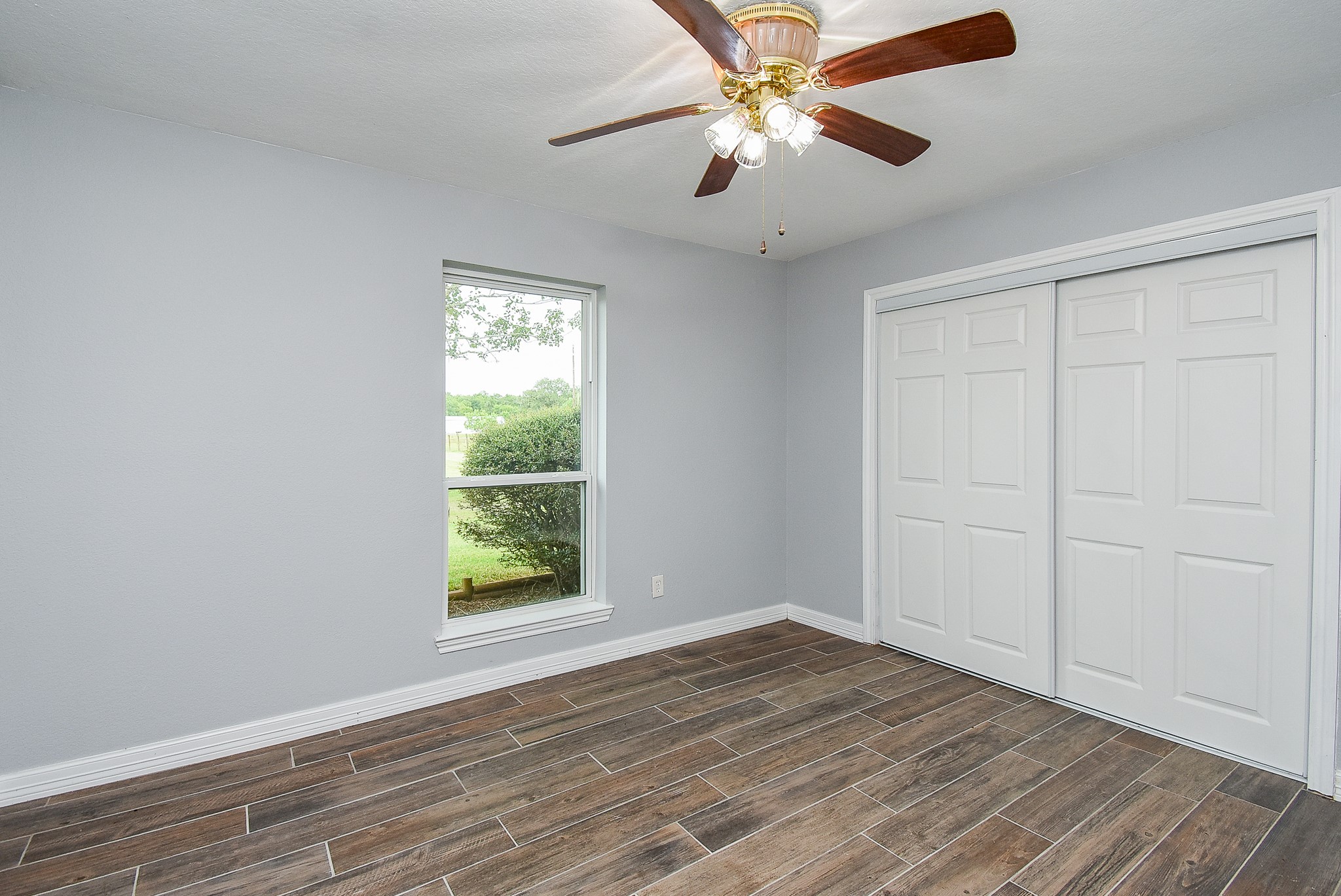 3818 County Road 36 Angleton, TX 77515 - Photo 32 of 49 an empty room with wooden floor chandelier fan and windows