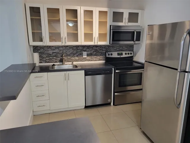 a kitchen with stainless steel appliances granite countertop a refrigerator and a stove