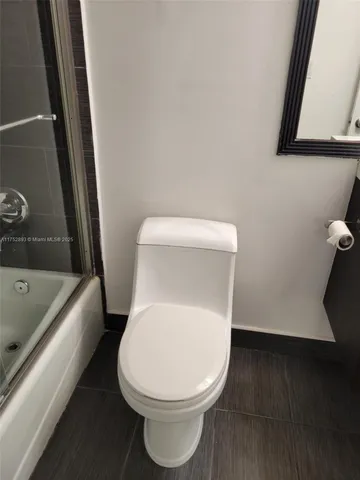 a white toilet sitting next to a bath tub