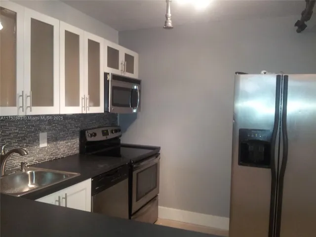 a kitchen with granite countertop a sink and a stove top oven