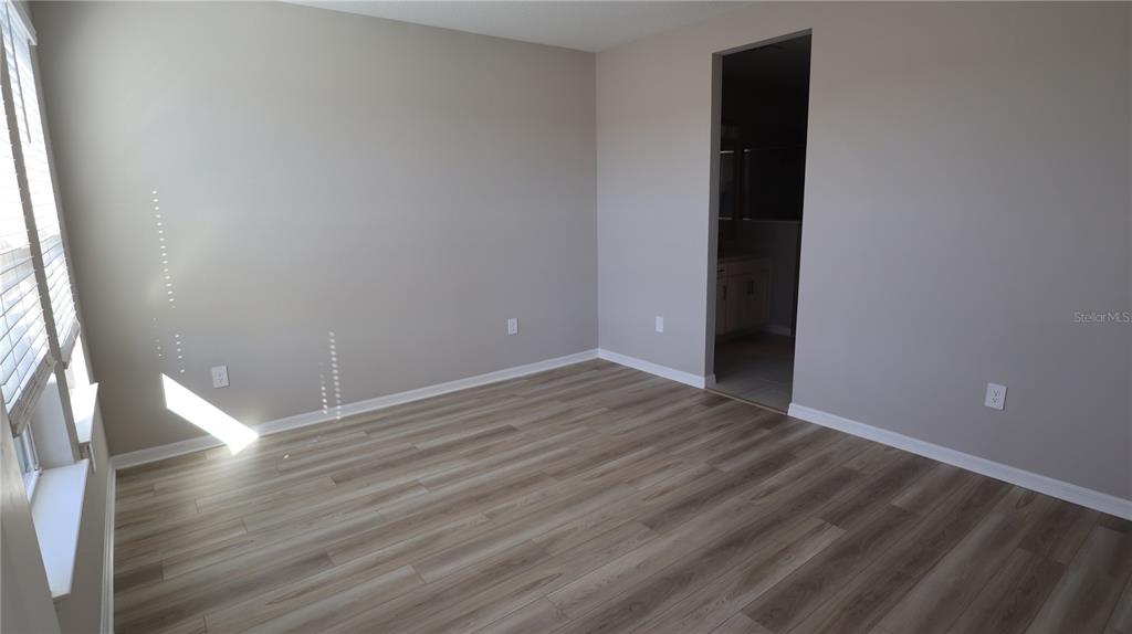 984 Top Minnow Road St. Cloud, FL 34771 - Photo 14 of 31 a view of an empty room with wooden floor and a window