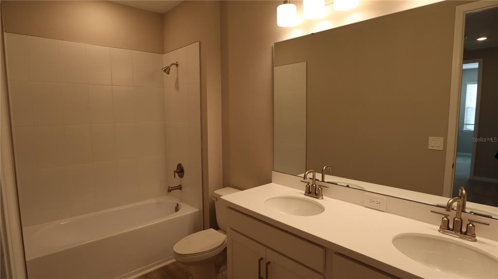 984 Top Minnow Road St. Cloud, FL 34771 - Photo 24 of 31 a bathroom with a granite countertop sink toilet and shower
