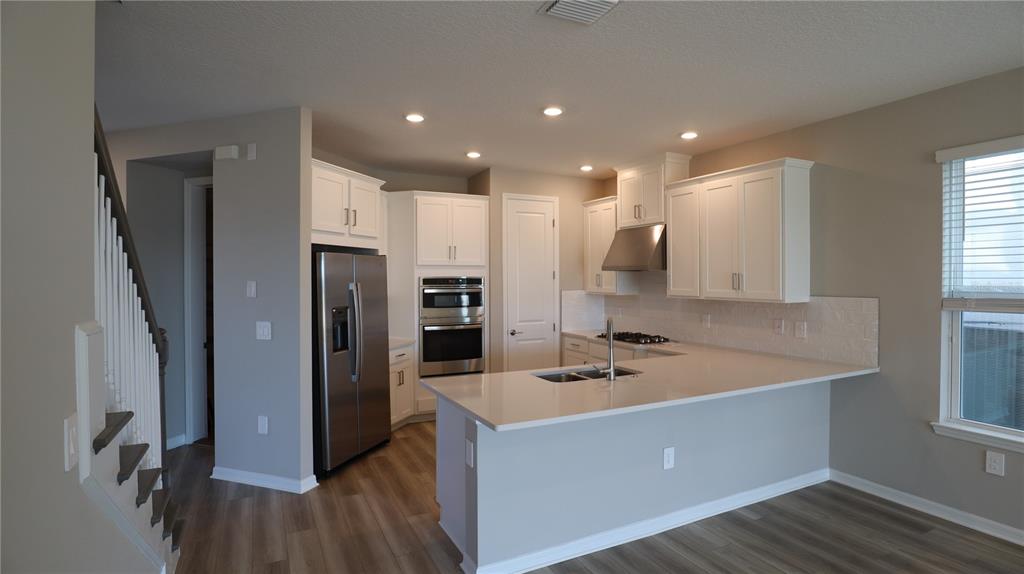 984 Top Minnow Road St. Cloud, FL 34771 - Photo 8 of 31 a kitchen with a sink a refrigerator and wooden floor