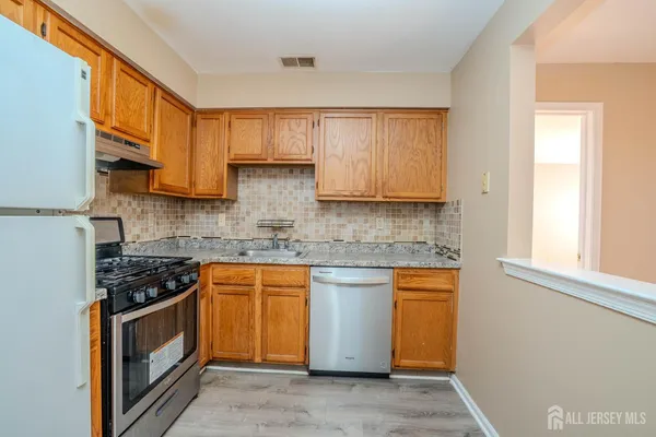 a kitchen with stainless steel appliances granite countertop a stove a sink and a microwave