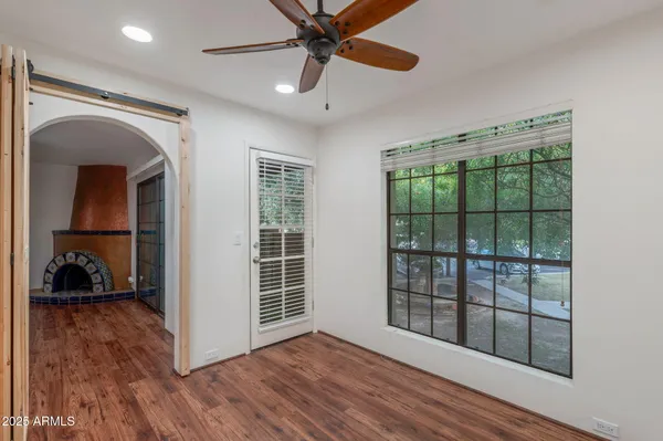 a view of an empty room with wooden floor and a window