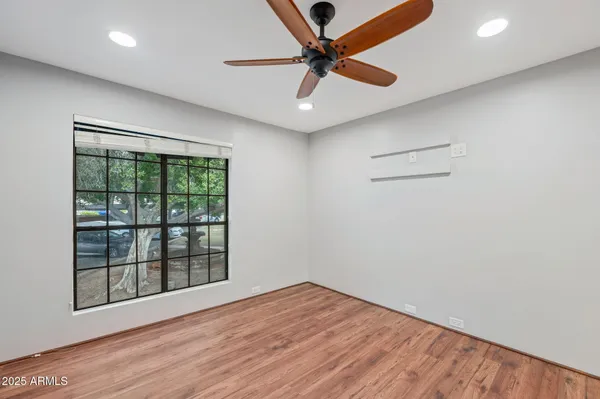 an empty room with wooden floor and windows