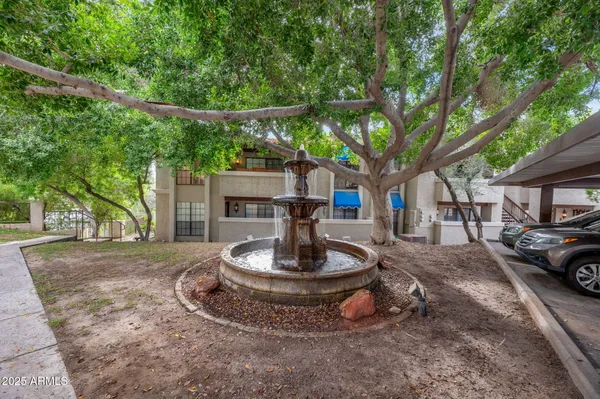 a view of an ocean with a huge green field and covered with trees