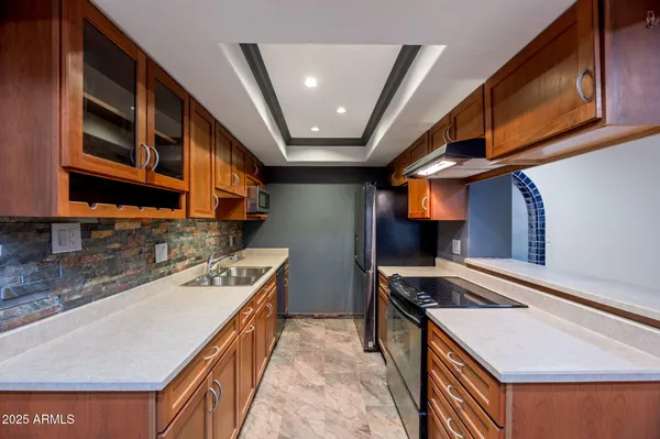 a kitchen with stainless steel appliances granite countertop a sink stove and cabinets