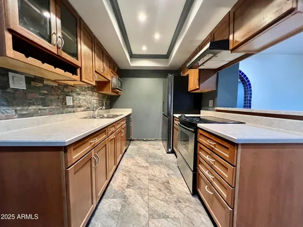 a kitchen with stainless steel appliances granite countertop a sink and a stove
