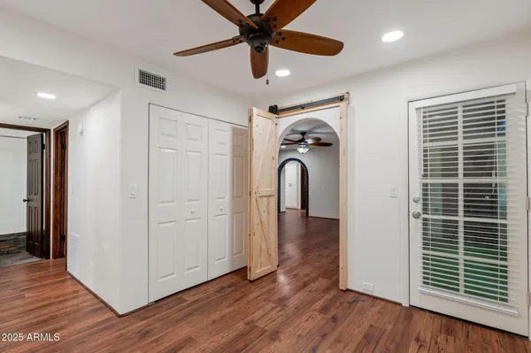 a view of a livingroom with wooden floor and a ceiling fan