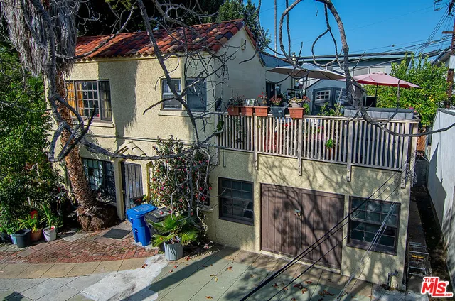 a view of a house with a small yard and potted plants