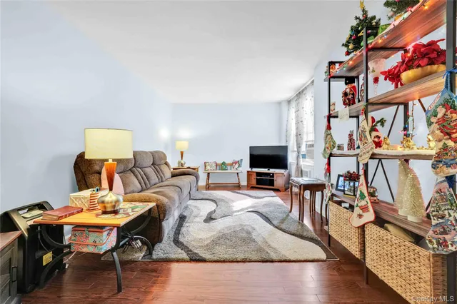 a living room with furniture a flat screen tv and a floor to ceiling window