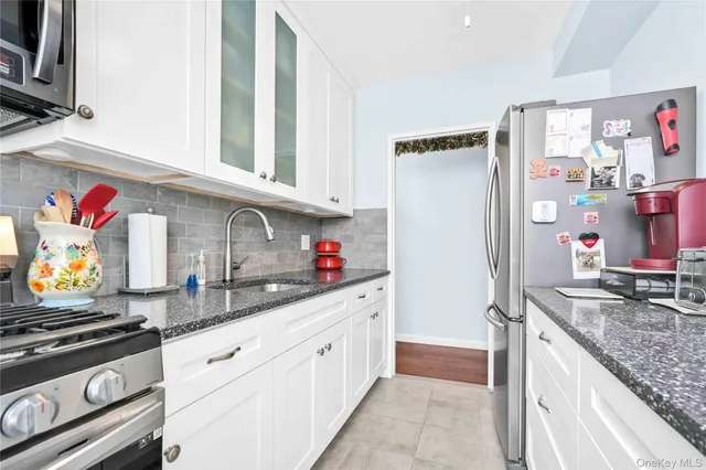 a kitchen with stainless steel appliances granite countertop a sink and a refrigerator