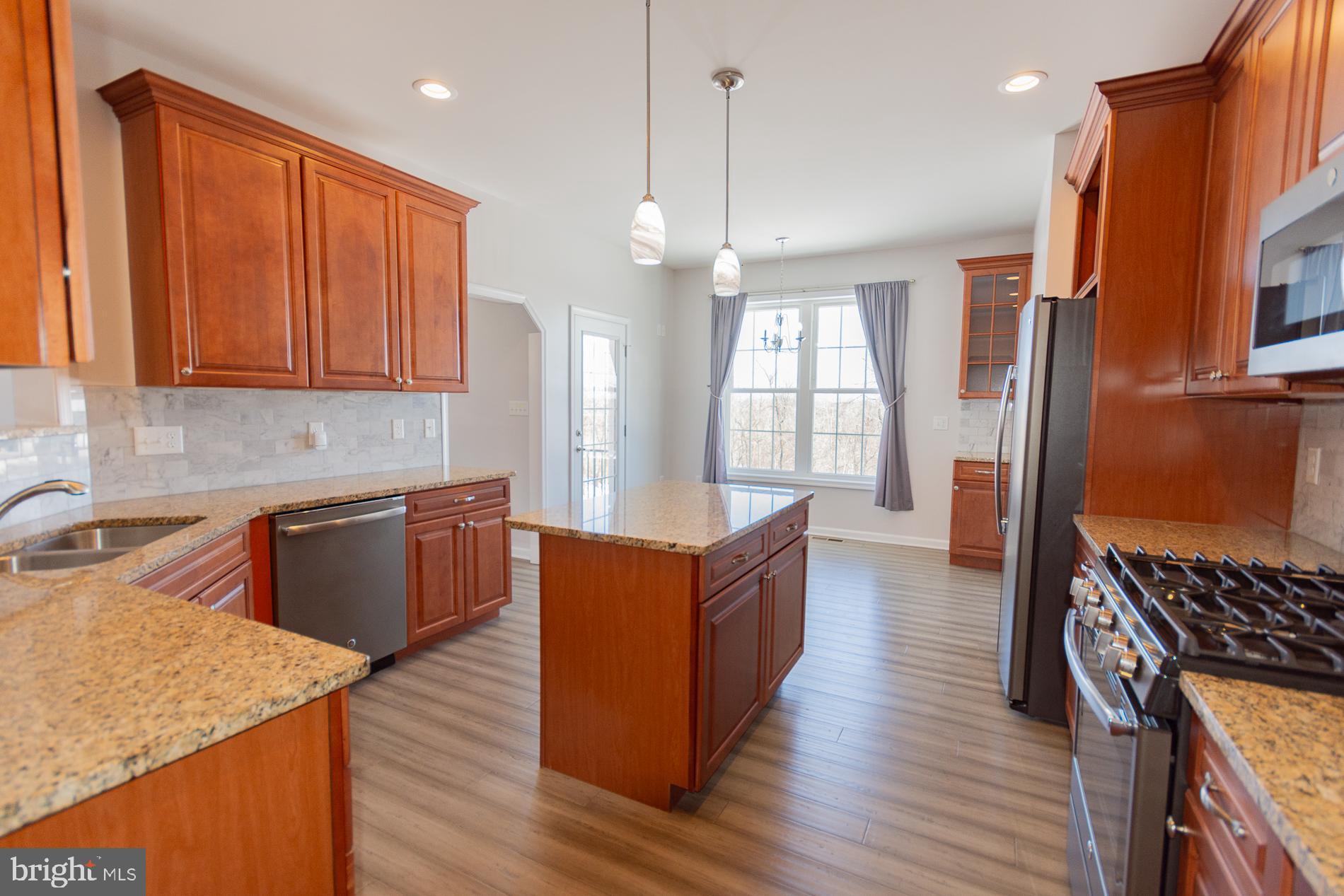 528 Delmar Orchard Road Martinsburg, WV 25403 - Photo 23 of 72 a kitchen with stainless steel appliances granite countertop wooden floors a stove a sink and a refrigerator