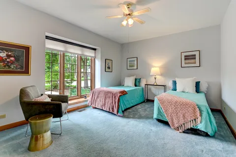 a spacious bedroom with a bed and a chandelier