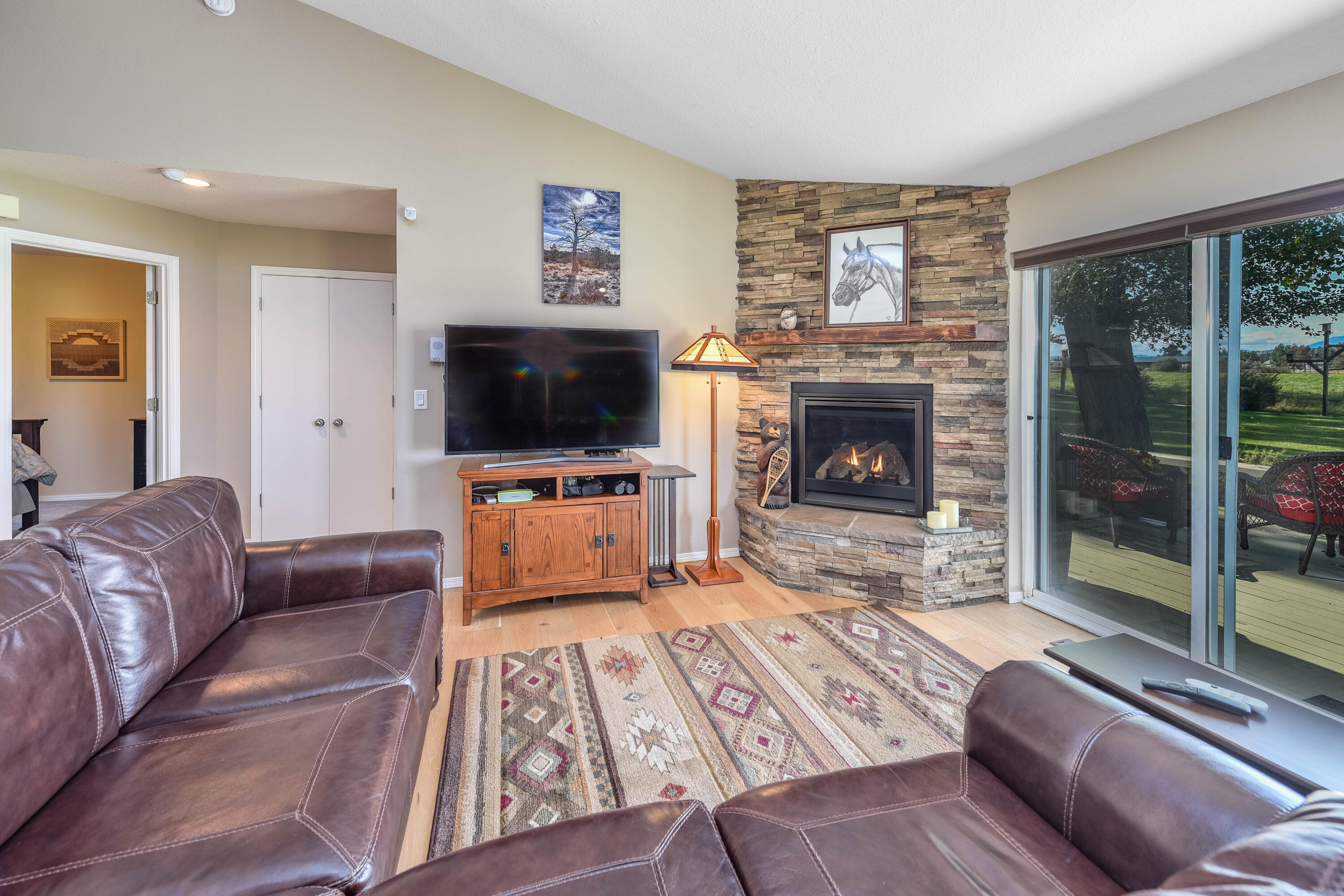 63475 Cricketwood Road Bend, OR 97701 - Photo 8 of 64 a living room with furniture a flat screen tv and a fireplace