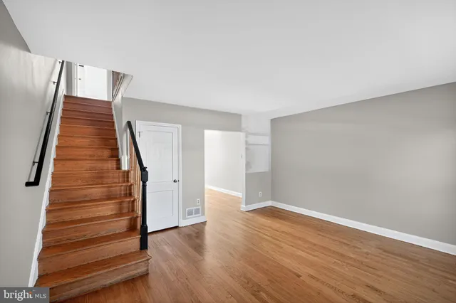 a view of a hallway with wooden floor and stairs