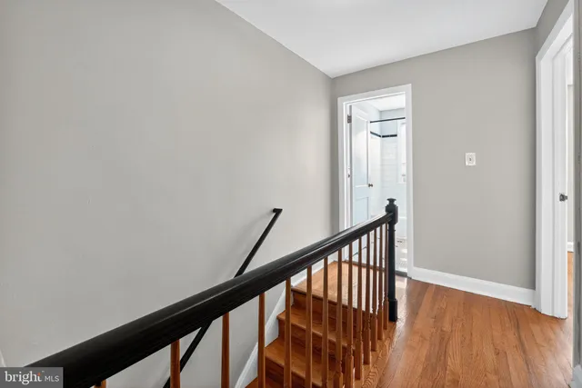 a view of a hallway with wooden floor and staircase