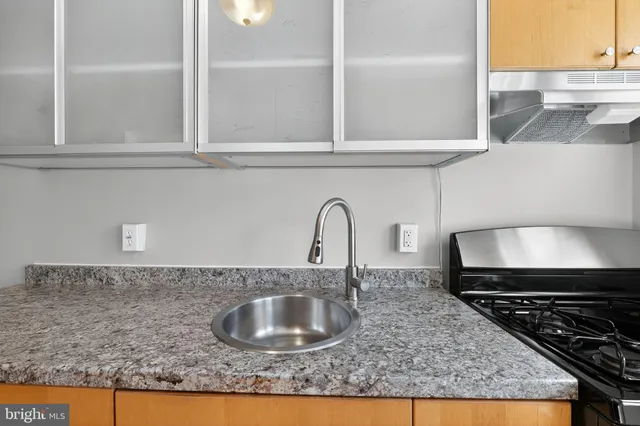 a kitchen with granite countertop a sink and a stove