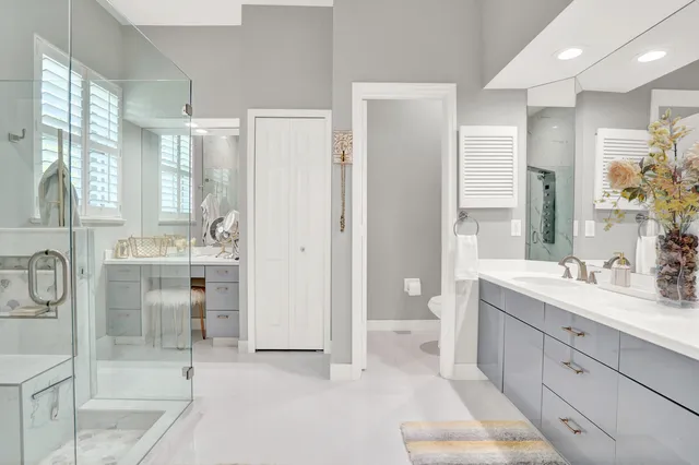 a bathroom with a double vanity sink mirror and toilet