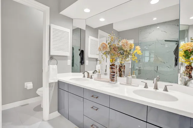 a living room with couches and kitchen view with wooden floor