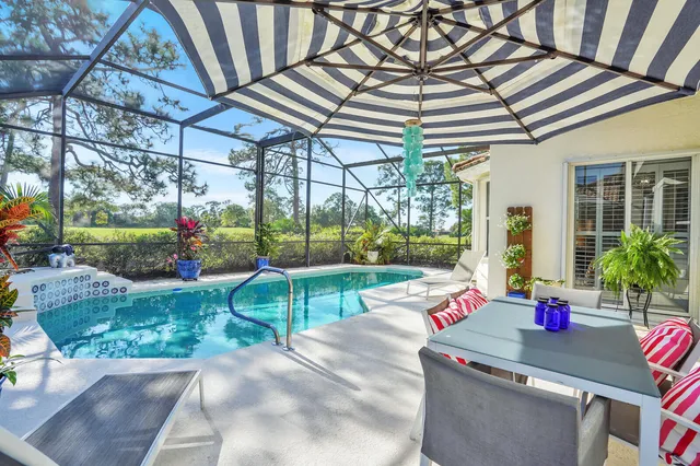 a view of a backyard with table and chairs potted plants