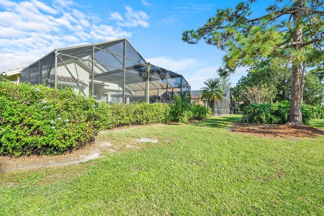 a view of a house with a big yard plants and large trees