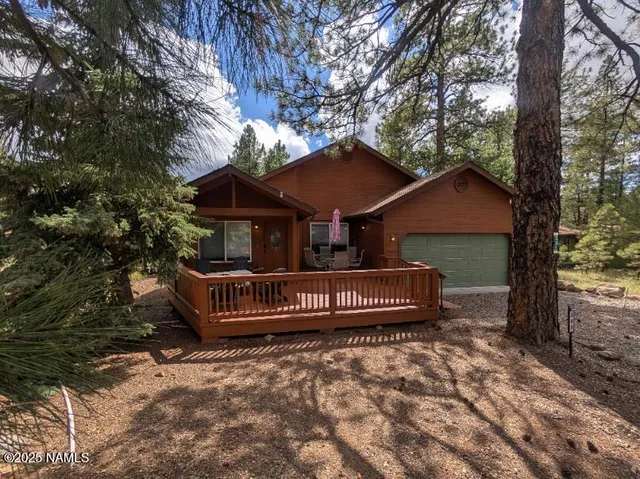 a front view of a house with a yard and a large tree