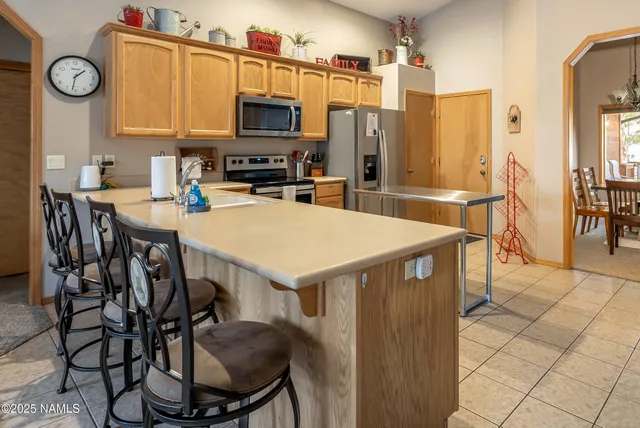 a kitchen with stainless steel appliances a table chairs and a refrigerator