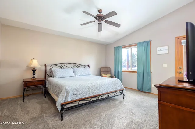 a spacious bedroom with a bed and a chandelier