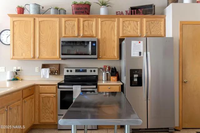 a kitchen with stainless steel appliances granite countertop a refrigerator a stove and a sink