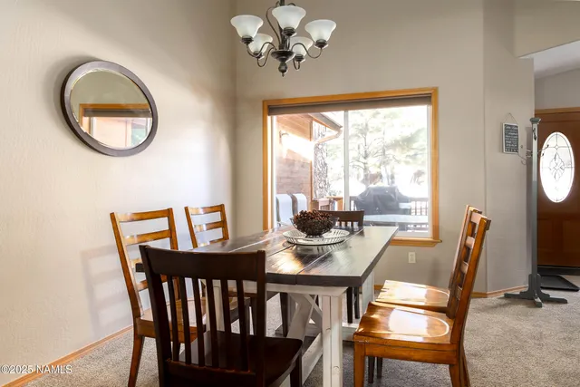 a view of a dining room with furniture a chandelier and wooden floor