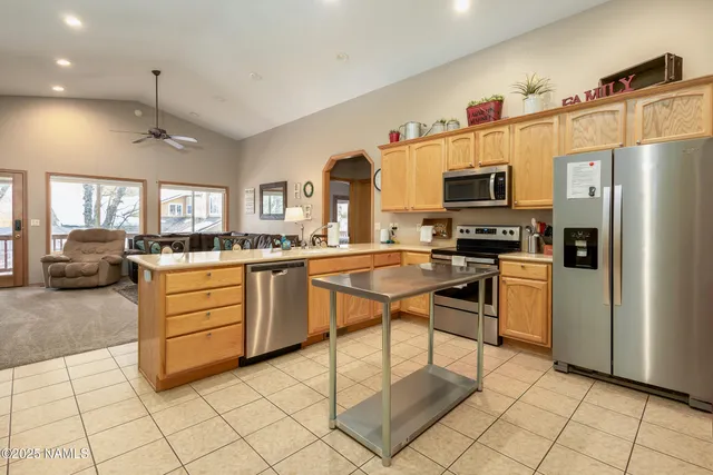 a kitchen with stainless steel appliances kitchen island granite countertop a refrigerator and a stove top oven