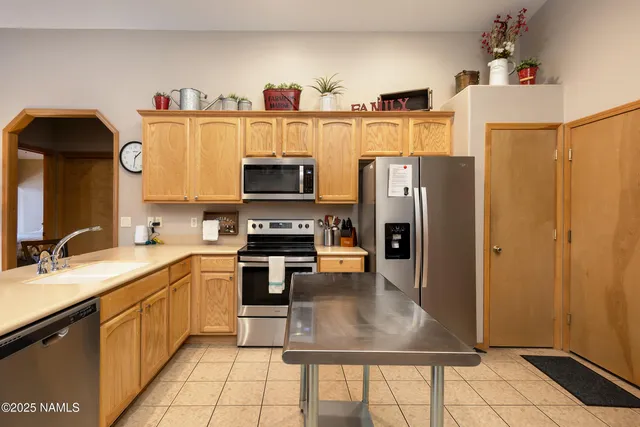 a kitchen with stainless steel appliances a stove refrigerator sink and microwave