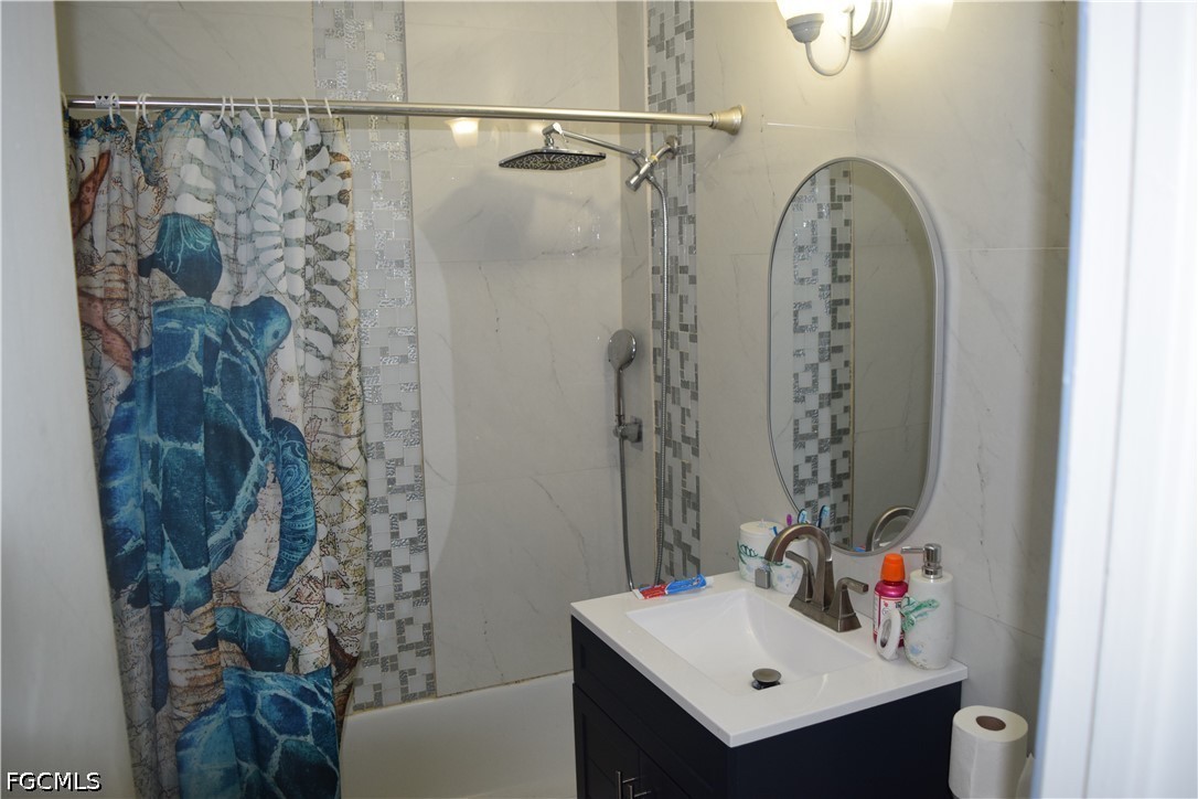 17 Colorado Road Lehigh Acres, FL 33936 - Photo 13 of 17 a bathroom with a sink mirror and shower